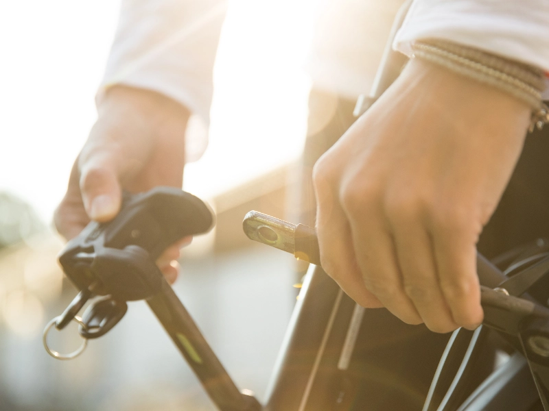 Eine Detailaufnahme eines Radfahrers, der sein Fahrradschloss schließt Eine Detailaufnahme eines Radfahrers, der sein Fahrradschloss schließt